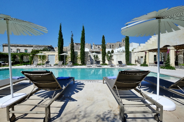 A outdoor swimming pool surrounded by sun loungers