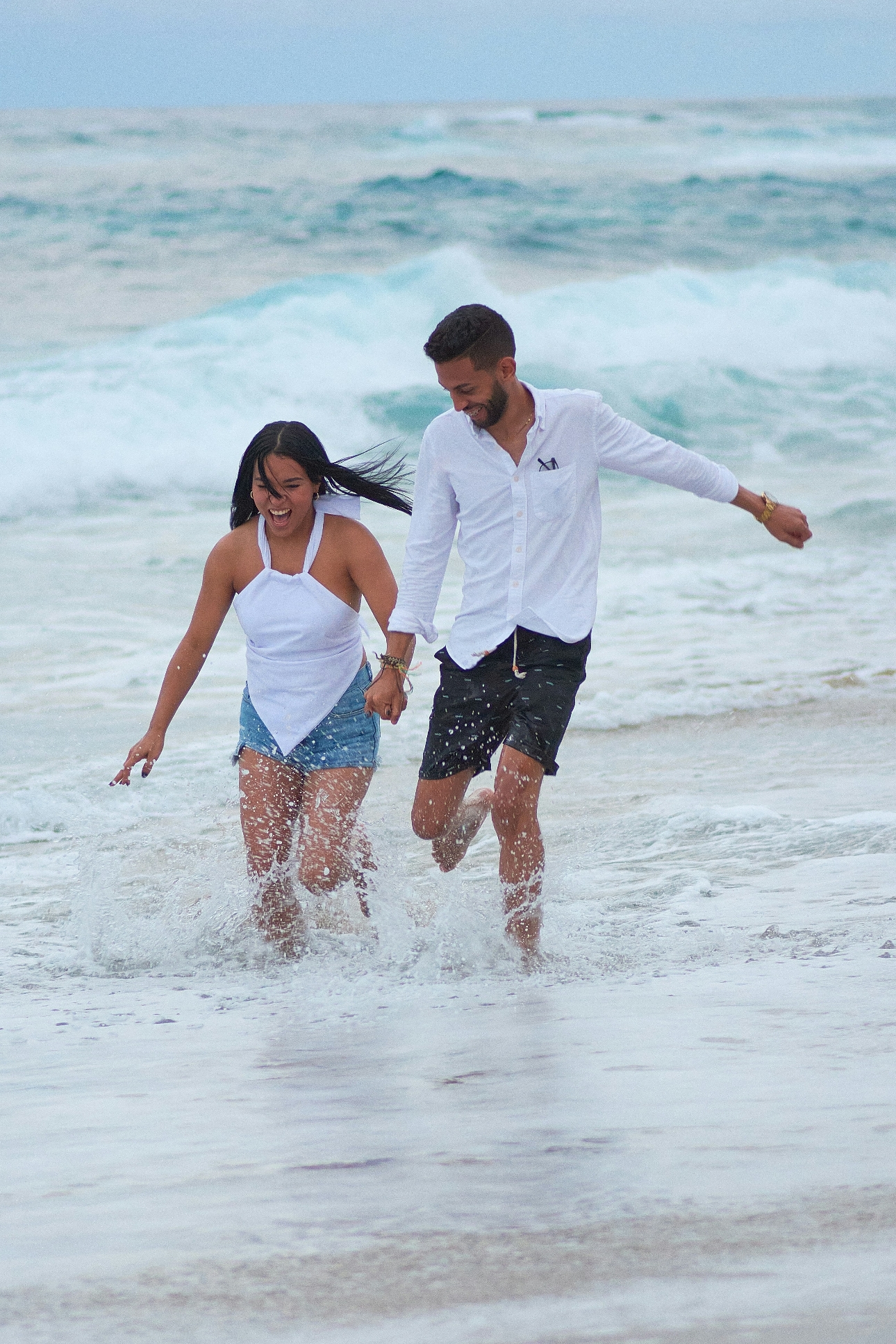 couple running through the sea