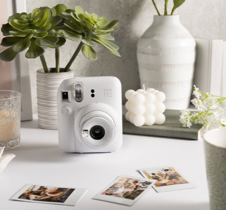 camera surrounded by photos on table