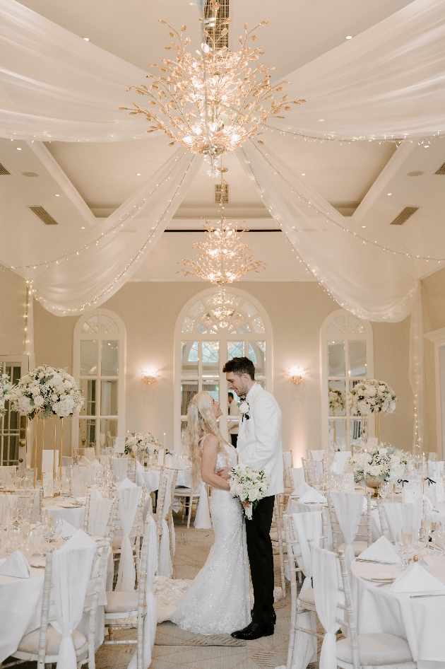 couple in wedding suite with stunning chandelier and draping 