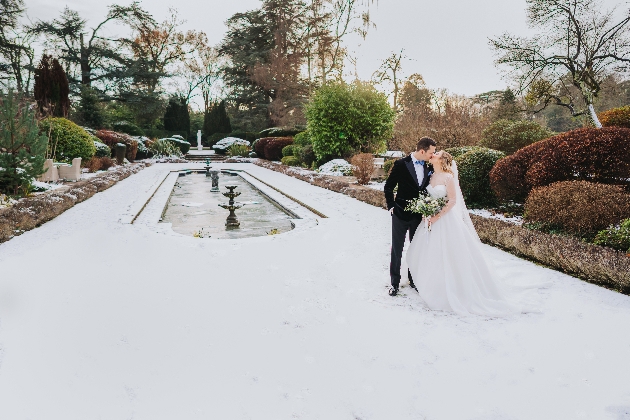 snowy garden with winter wedding couple